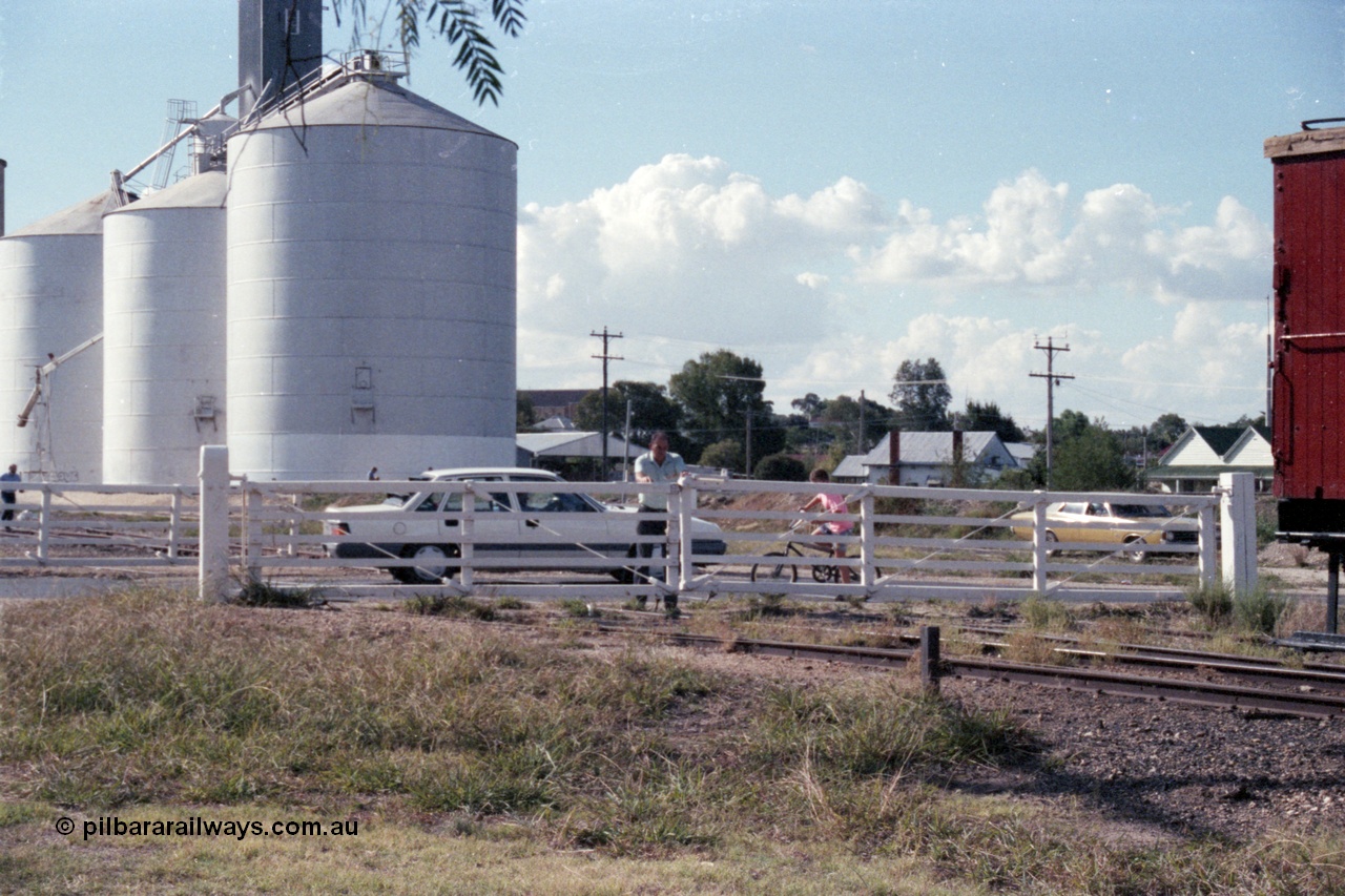 143-37
Rutherglen, the non-interlocked hand operated swing gates on Howlong St are closed following the departure of the up 'Stringybark Express' mixed special, the trailing edge of ZL 2 just visible, Ascom silos in the background.
