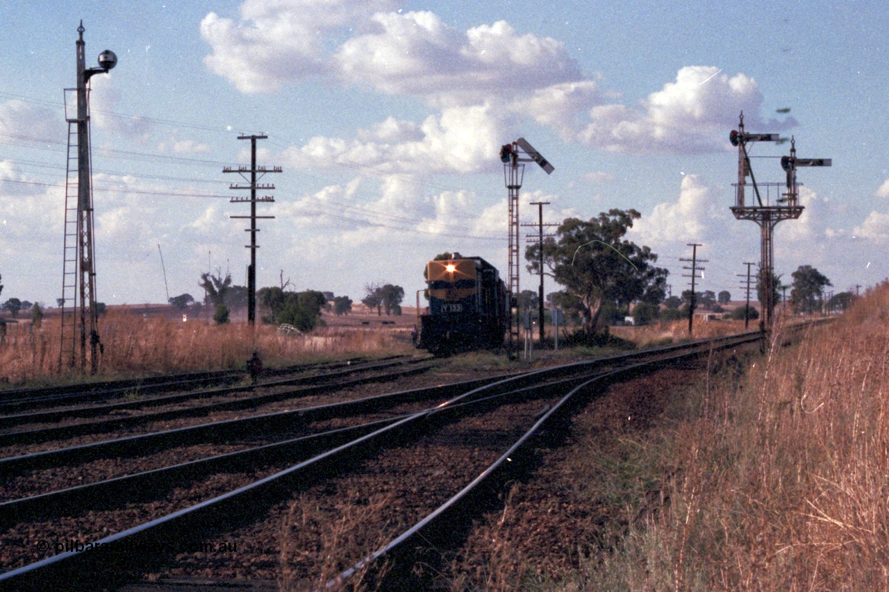 144-03
Springhurst yard view looking north, up Wahgunyah 'Stringybark Express' mixed special hauled by broad gauge VR liveried Y class Y 133 Clyde Engineering EMD model G6B serial 65-399 on the Wahgunyah line pulls forward into Springhurst at semaphore signal Post 6, the Up Home Wahgunyah Line to No. 2 Rd to Post 3, the other signals are disc Post 5 from Siding A to No. 2, 3, 4 or 5 Roads and on the right is semaphore signal Post 8 the Up Home Wodonga Line, the embankment at the far right is the standard gauge flyover.
Keywords: Y-class;Y133;Clyde-Engineering-Granville-NSW;EMD;G6B;65-399;