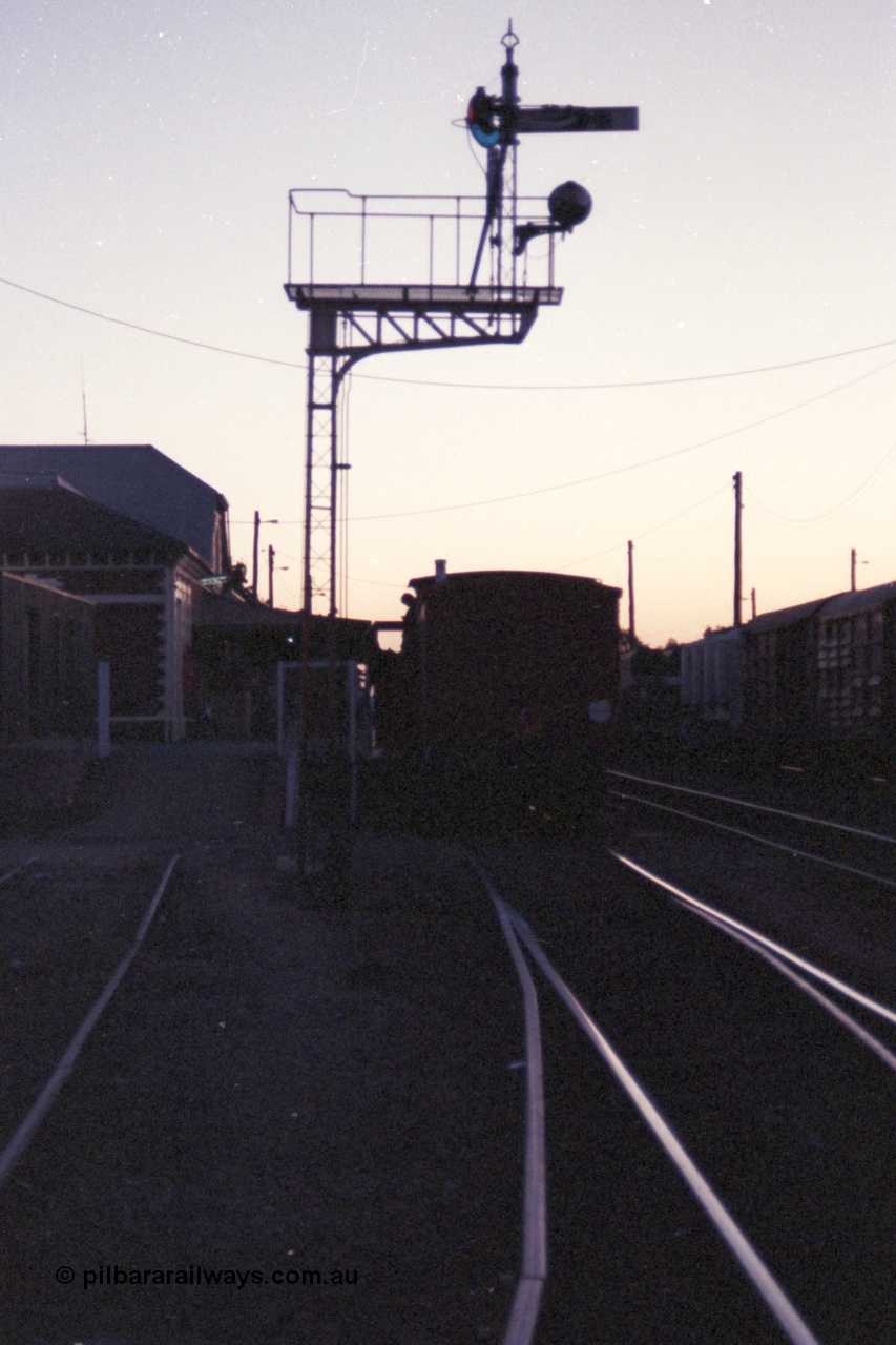 144-19
Benalla station platform, silhouette image of ZL type six wheel guards van ZL 2 on the up Wahgunyah 'Stringybark Express' mixed and semaphore signal Post 11.
