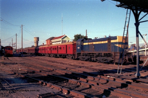144-09
Wangaratta yard view, Victorian Railways liveried broad gauge Y class Y 133 Clyde Engineering EMD model G6B serial 65-399 holds the up Wahgunyah mixed special the 'Stringybark Express' in No. 2 Rd while V/Line rail tractor RT class RT 5 looks on from No. 5 Rd. The water tank in the background is the town water supply, the railways tank is just visible on the left edge of shot.
Keywords: Y-class;Y133;Clyde-Engineering-Granville-NSW;EMD;G6B;65-399;