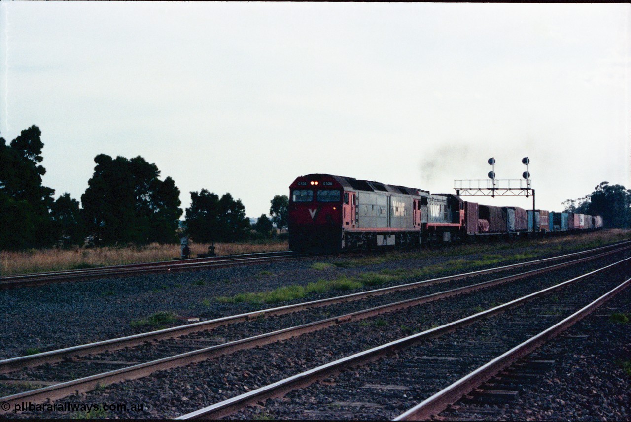 145-21
Wallan Loop, north end of standard gauge loop, V/Line G class G 526 model JT26C-2SS serial 88-1256 leads V/Line 3rd series X class with a down Albury bound goods pass under the signal gantry, broad gauge lines in the foreground.
Keywords: G-class;G526;Clyde-Engineering-Somerton-Victoria;EMD;JT26C-2SS;88-1256;