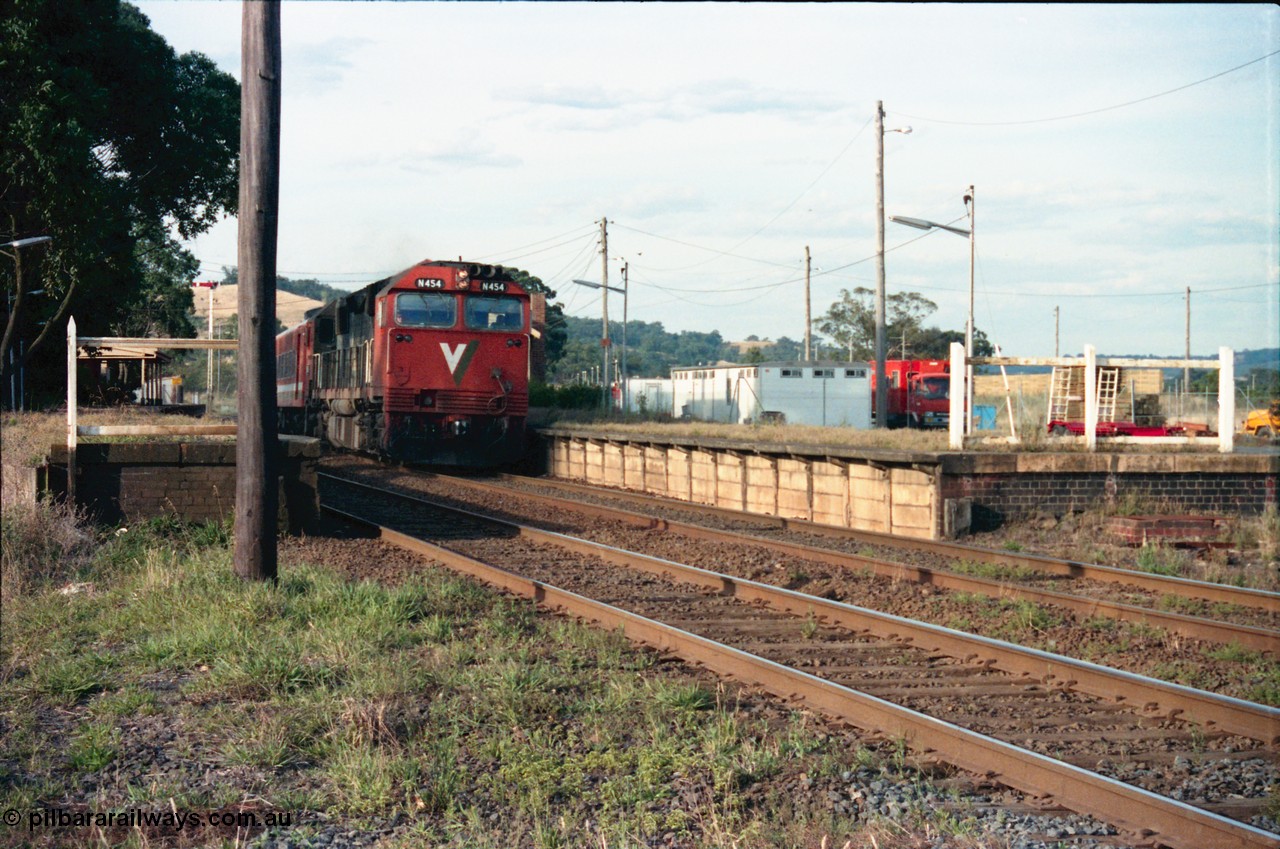 145-26
Wallan, up broad gauge passenger train under the power of V/Line N class N 454 'City of Horsham' Clyde Engineering EMD model JT22HC-2 serial 85-1222 rolls through the platform, V/Line gang camp behind platform.
Keywords: N-class;N454;Clyde-Engineering-Somerton-Victoria;EMD;JT22HC-2;85-1222;