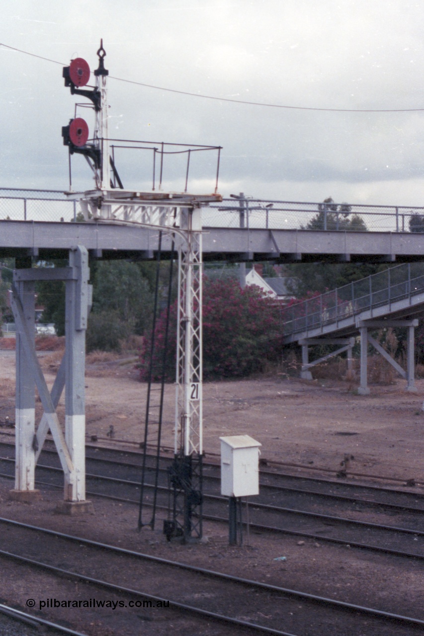 148-05
Wangaratta, disc signal post 21, Up signals from Siding C to No.2 Road towards post 14, and to No.3 Road towards post 15, telephone cabinet for signal box at foot of post, footbridge behind, looking south from footbridge ramp.
