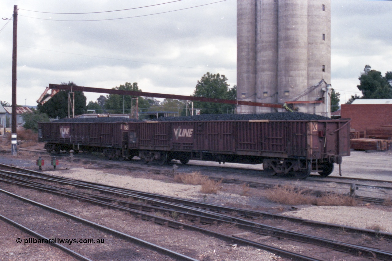 148-14
Wangaratta, V/Line VOCX bogie open waggons, VOCX 122, loaded with briquettes on the old works platform road, looking towards Sidings E, silos in the background. VOCX 122 was built by Ballarat North Workshops May 1968 as ELX type ELX 122. In 1979 re-coded to VOCX. In 1994 re-coded to ROBX.
Keywords: VOCX-type;VOCX122;Victorian-Railways-Ballarat-Nth-WS;ELX-type