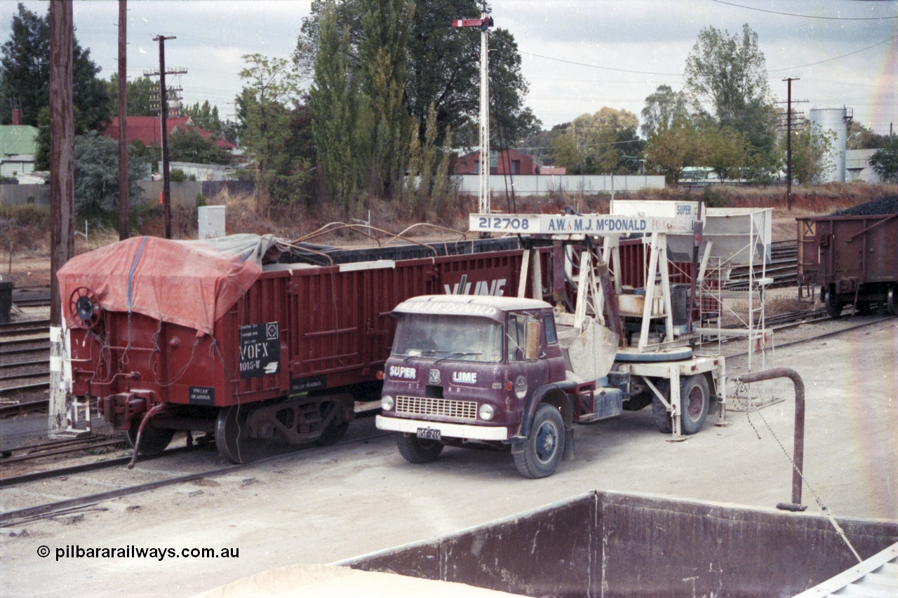 148-20
Wangaratta, V/Line freshly repainted broad gauge VOFX bogie open waggon VOFX 1018 with super phosphate and Bedford TK unloading grab looking from grounded waggons, semaphore signal post 12 in the background. VOFX 1018 started life as ELX 1018 built by Bendigo Workshops December 1974, recoded to VOCX 1018 in 1981. Recoded to VOFX in 1987-88.
Keywords: VOFX-type;VOFX1018;Victorian-Railways-Bendigo-WS;ELX-type;