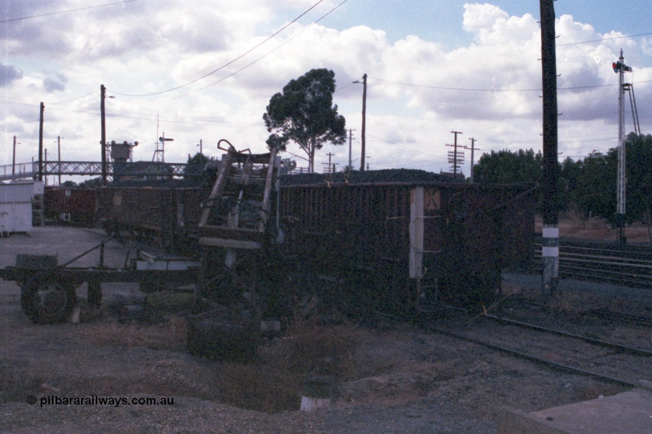 148-23
Wangaratta, V/Line VOCX type bogie open waggons loaded with briquettes, rudimentary unloading contraption, looking north, image is very dark.
