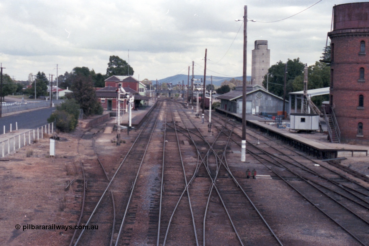 148-31
Wangaratta yard looking south from footbridge with Siding A going into dock with K crossing removed, signal post 20 pulled off, number 1, 2 and 3 Roads with the double compound points leading across to number 4 and 5 Roads, goods shed and platform slewing crane, Freight Gate awning and water tower, grain silos in the background.
