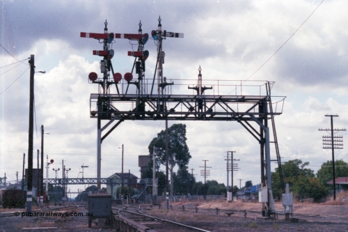 148-25
Wangaratta, Signal Bridge, Down Signal Posts 7, 8 and stripped 10 facing camera, Up Post 9 facing away. Signal Post 7 two arms and two discs, Top arm Home Signal 'A' to No.2 Road to Post 17, Bottom arm Calling-on Signal from 'A' to No. 2 Road towards Post 17. Left-hand Disc from 'A' to No. 4 or 5 Roads towards Post 19; or to No. 6 Road. Right-hand Disc from 'A' to No. 3 Road towards Post 17. Signal Post 8 two arms one disc, Top arm Home Signal from 'A' to No. 1 Road to Post 20, Bottom arm Calling-on Signal from 'A' to No. 2 Road towards Post 20. The Disc from 'A' to Carriage Dock. Stripped Disc Post 10 was from 'B' to No. 1 Road towards Post 20 and from 'B' to Carriage Dock.
