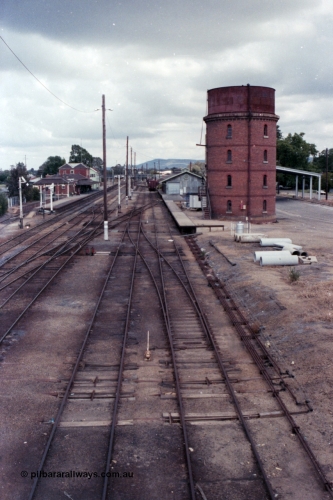 148-34
Wangaratta yard looking south (Up direction) from footbridge, from extreme left, Siding 'A', Signal Post 20 pulled off, Main Line or No. 1 Road, No. 2 Road, No. 3 Road, No. 4 Road and No. 5 Road, goods shed and platform and water tower with Freight Gate awning behind, point rodding and signal wires visible.
