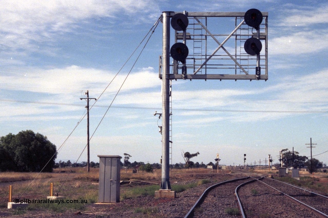 149-04
Rockbank, track view looking Up direction towards Deer Park, Station Rd crossing, cantilevered signal post with searchlight signals 12 (No. 2 Road) and 10 )No. 1 Road) Up Home Signals.
