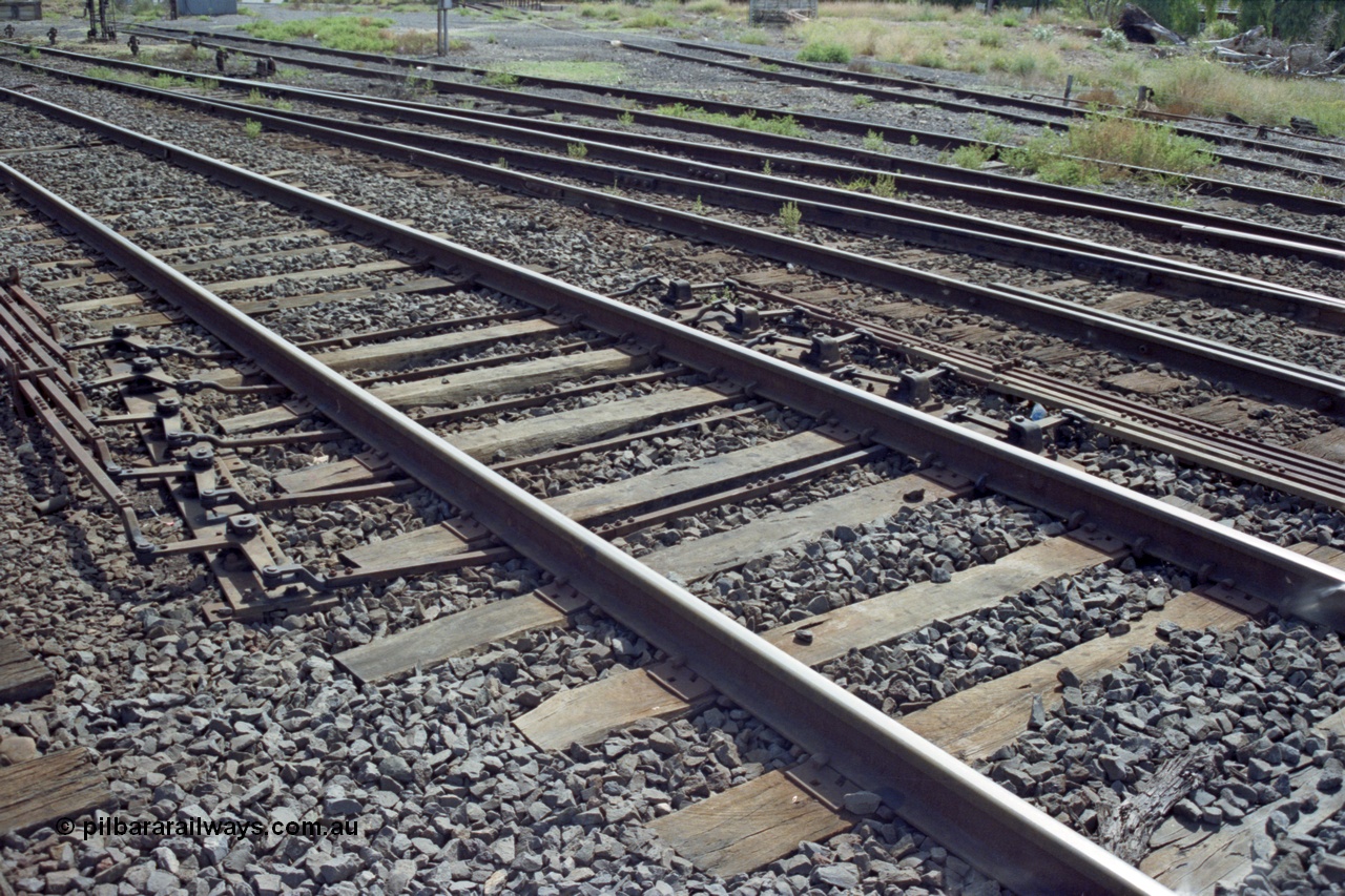 149-13
Bacchus Marsh, track view of point rodding changing track sides under rails with pivots.
