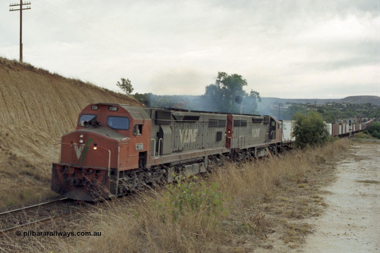 149-25
Bacchus Marsh, V/Line C class locos C 508 Clyde Engineering EMD model GT26C serial 76-831 and C 5?? Power a Melbourne bound 9150? Goods train away from the Marsh at Frisken St, the distant signal can be seen above the trailing C class.
