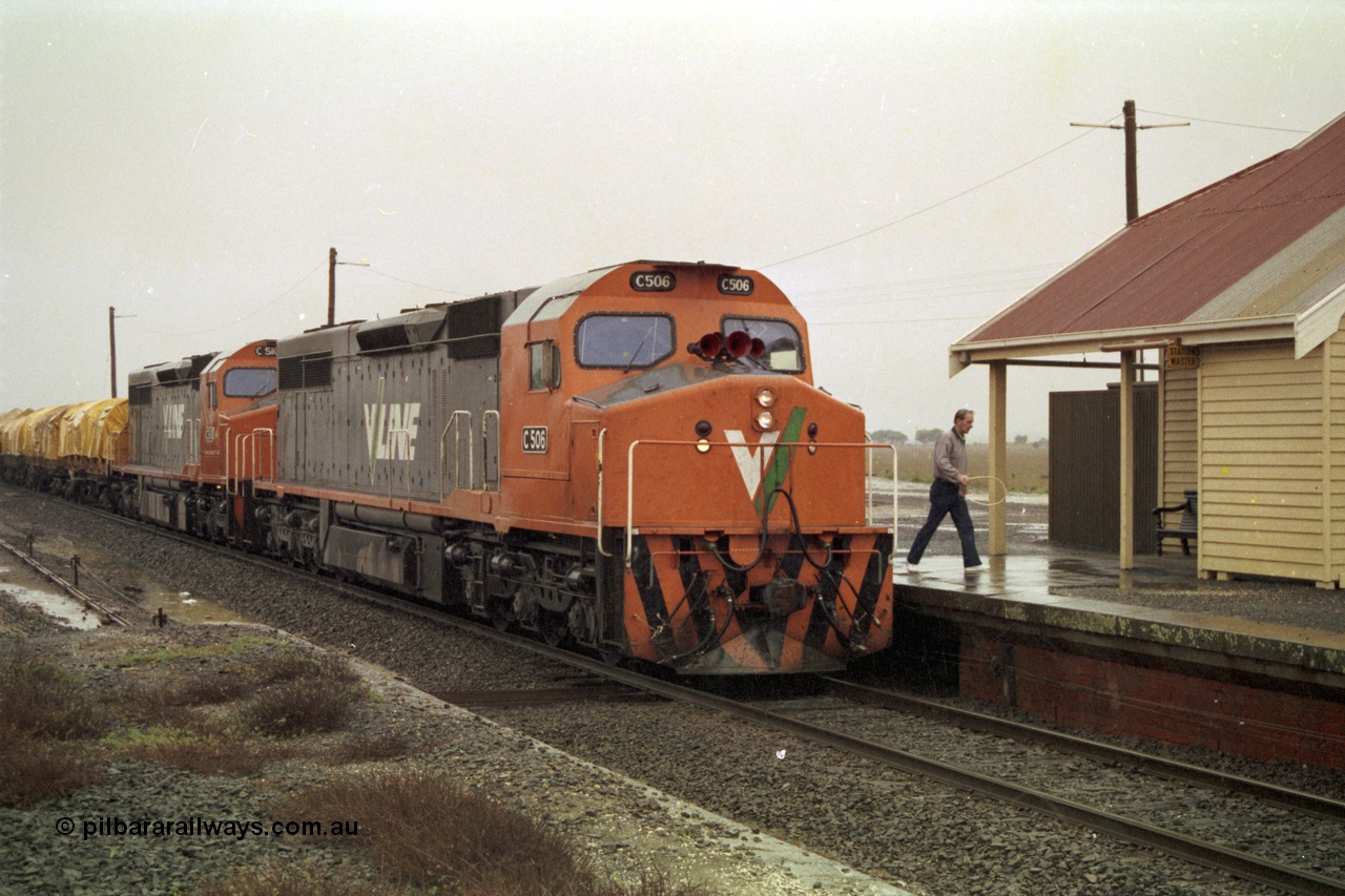 150-08
Gheringhap, V/Line broad gauge C class pair of C 506 Clyde Engineering EMD model GT26C serial 76-829 and C 510 serial 76-833 have paused to swap the electric staff for a train order, signaller has the staff and hoop, raining, train is 9169 Adelaide bound goods via Cressy.
Keywords: C-class;C506;Clyde-Engineering-Rosewater-SA;EMD;GT26C;76-829;