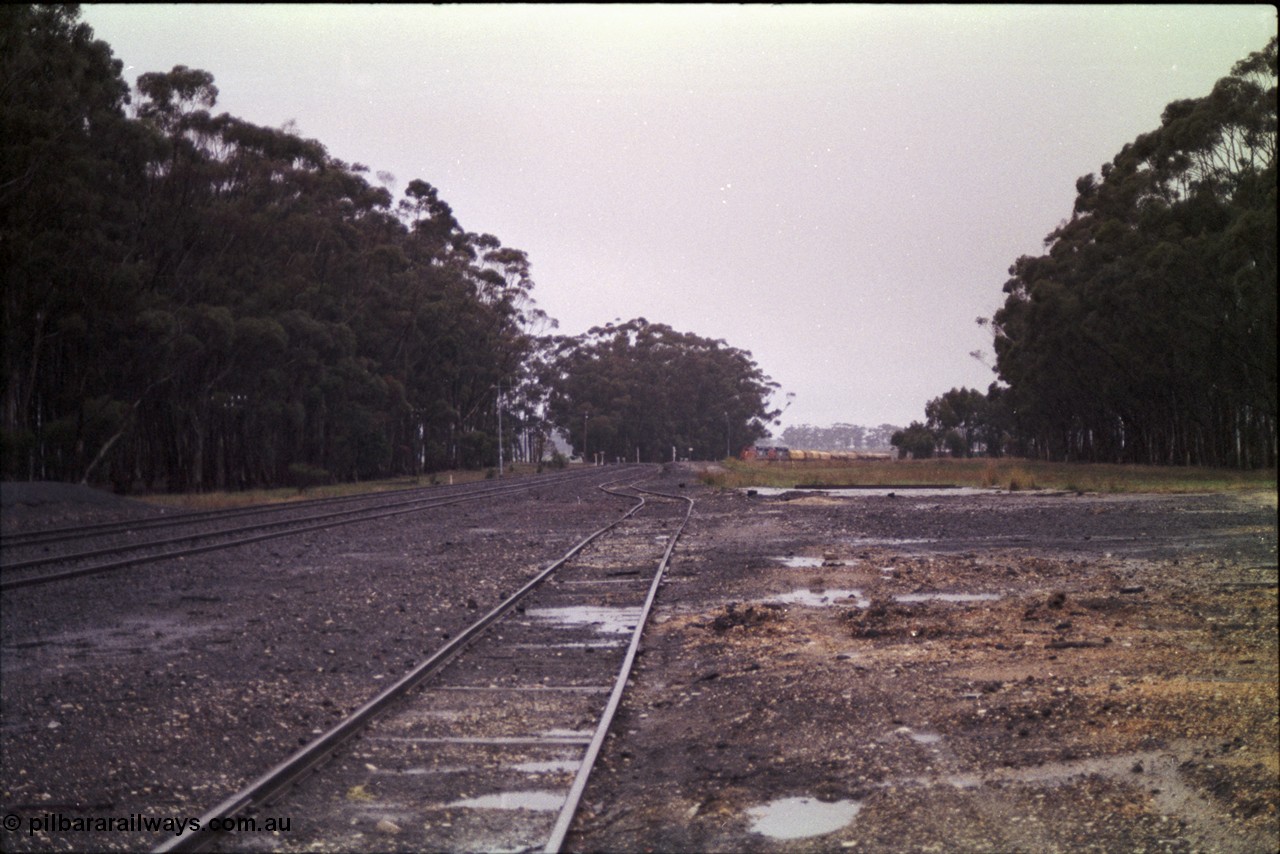 150-13
Lismore, station yard overview looking towards Melbourne from goods loading ramp, V/Line broad gauge C classes Clyde Engineering EMD model GT26C leading Adelaide bound goods train 9169 at the trailable points which are set for left hand lay.
