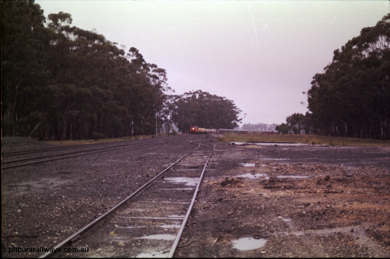 150-14
Lismore, station yard overview looking towards Melbourne from goods loading ramp, V/Line broad gauge C classes Clyde Engineering EMD model GT26C leading Adelaide bound goods train 9169 at the trailable points which are set for left hand lay.
