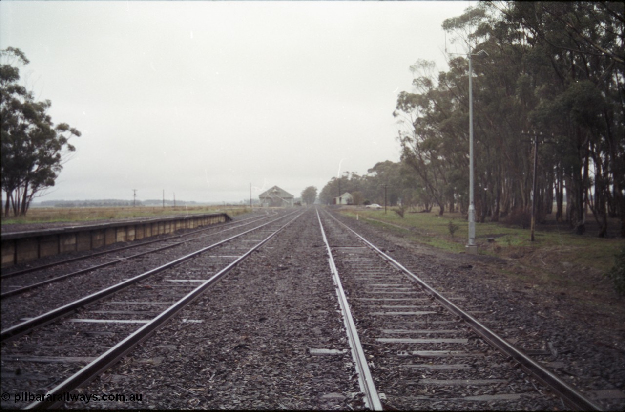 150-32
Lismore station yard overview from Melbourne end, goods loading platform on No.3 road at left, grain bunker in the distance, station building on the right, taken from No.1 road.
