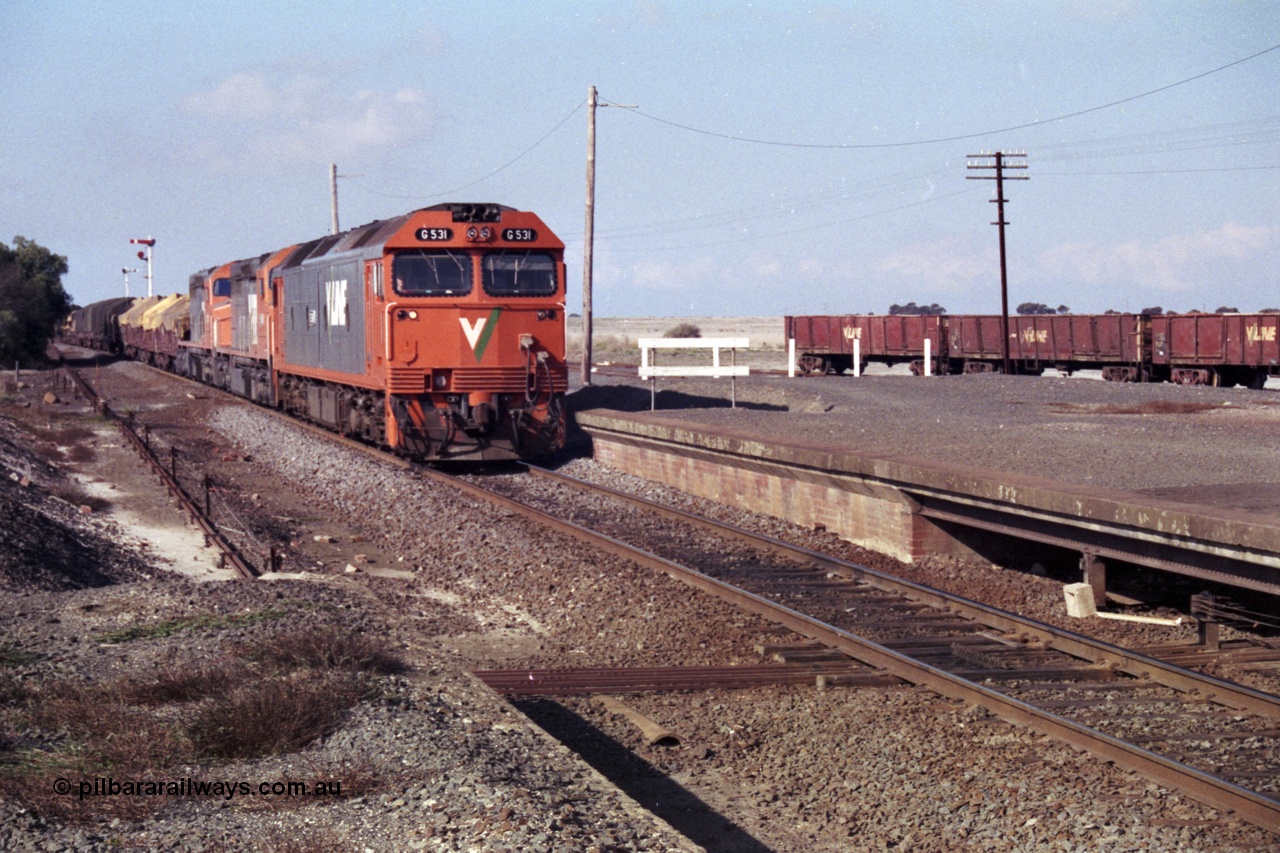 151-12
Gheringhap, broad gauge V/Line Adelaide bound goods train 9169 arrives on No.1 Road under the power of G class G 531 Clyde Engineering EMD model JT26C-2SS serial 88-1261, C class C 510 Clyde Engineering EMD model GT26C serial 76-833 and C 509 serial 76-832, point rodding and signal wires can been seen in this shot taken from the former No.2 platform, gypsum waggons in the background.
Keywords: G-class;G531;Clyde-Engineering-Somerton-Victoria;EMD;JT26C-2SS;88-1261;