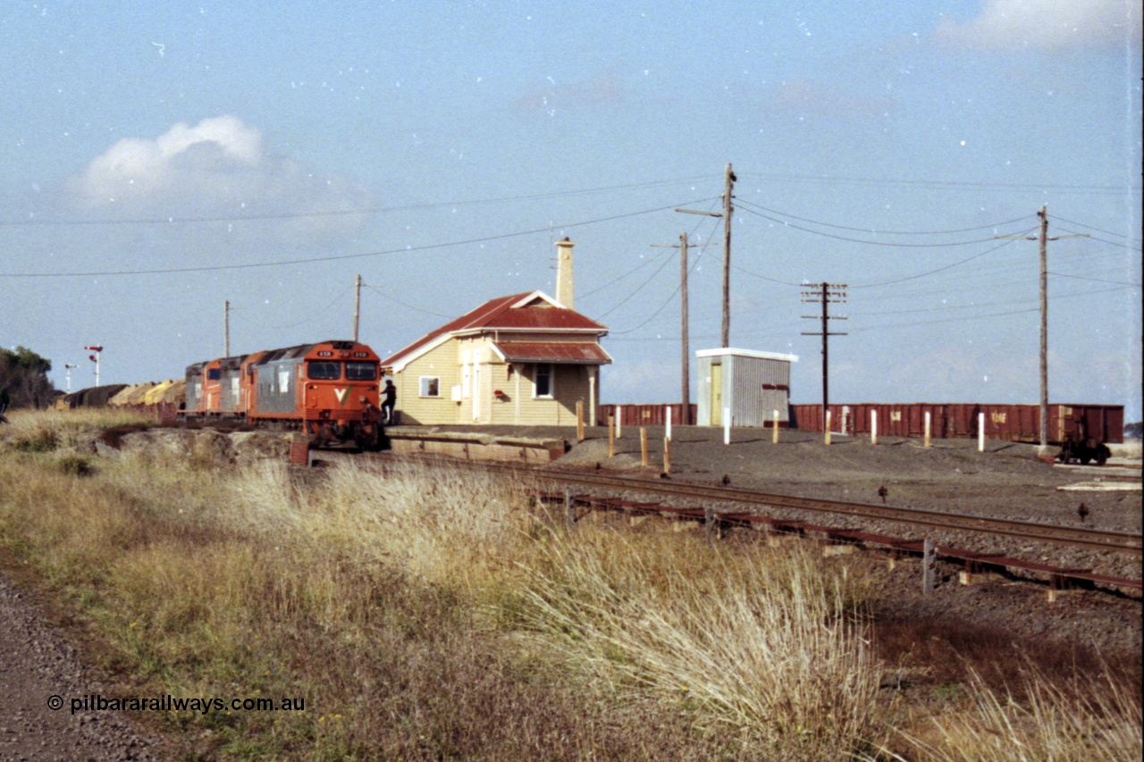 151-15
Gheringhap, broad gauge V/Line Adelaide bound goods train 9169 on No.1 Road under the power of G class G 531 Clyde Engineering EMD model JT26C-2SS serial 88-1261, C class C 510 Clyde Engineering EMD model GT26C serial 76-833 and C 509 serial 76-832, station overview from beyond the former No.2 platform, gypsum waggons in the background, crew boarding having changed electric staff for train order.
Keywords: G-class;G531;Clyde-Engineering-Somerton-Victoria;EMD;JT26C-2SS;88-1261;