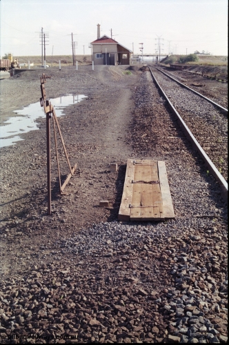 151-09
Gheringhap, view from Geelong end looking towards Maroona and Ballarat, automatic electric staff exchange apparatus cover and set-up gauge for down trains, similar unit for up trains visible on the right hand side of line, station building and former second platform visible in the distance, along with signal post four.
