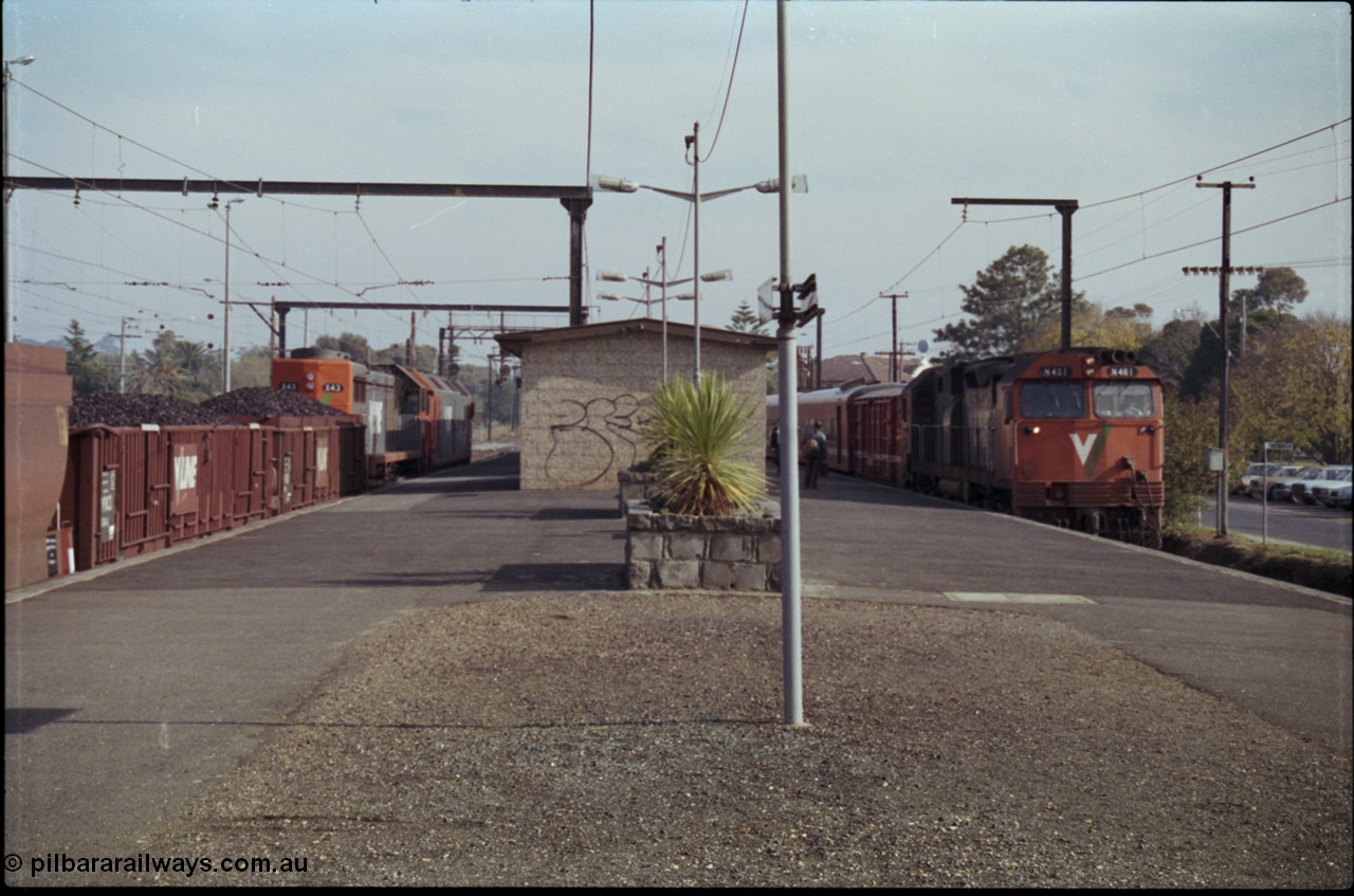 152-12
Pakenham station, V/Line broad gauge up 9444 goods to Nth Geelong with G class G 543 Clyde Engineering EMD model JT26C-2SS serial 89-1276 and X class X 43 Clyde Engineering EMD model G26C serial 70-706 their load of briquettes undertake a crew change as V/Line N class N 461 'City of Ararat' Clyde Engineering EMD model JT22HC-2 serial 86-1190 with D van and N set run down passenger train 8411 to Traralgon.
