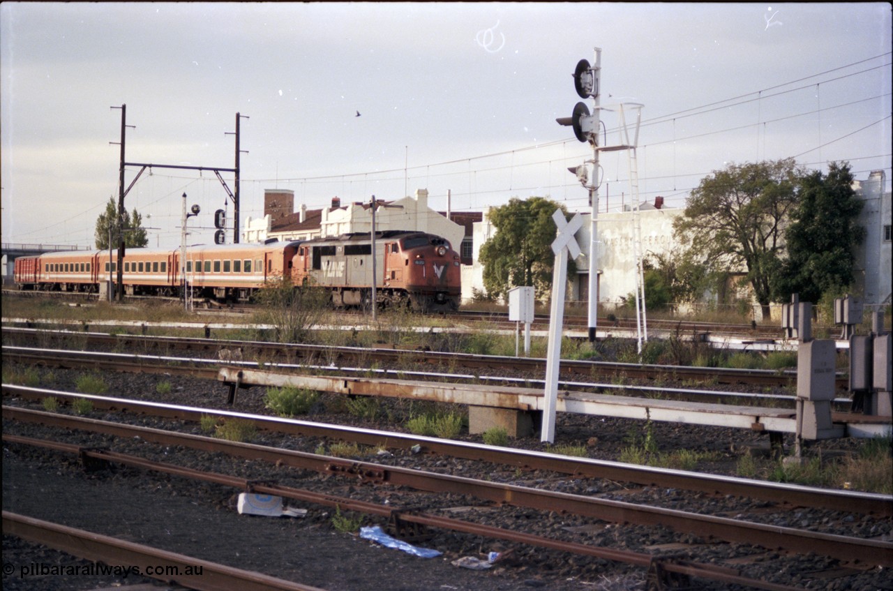 153-1-01
Sunshine, looking across tracks at V/Line broad gauge A class loco A 70 Clyde Engineering EMD model AAT22C-2R serial 84-1187 rebuilt from B 70 Clyde Engineering EMD model ML2 serial ML2-11 and N set with an up passenger train on the Bendigo lines.
Keywords: A-class;A70;Clyde-Engineering-Rosewater-SA;EMD;AAT22C-2R;84-1187;rebuild;bulldog;