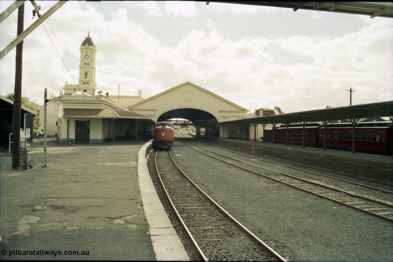 153-1-12
Ballarat station building, platform and yard overview looking from the east end of the platform and through canopy, broad gauge V/Line A class A 79 Clyde Engineering EMD model AAT22C-2R serial 84-1188 rebuilt from B 79 Clyde Engineering EMD model ML2 serial ML2-20 at platform.
Keywords: A-class;A79;Clyde-Engineering-Rosewater-SA;EMD;AAT22C-2R;84-1188;rebuild;bulldog;