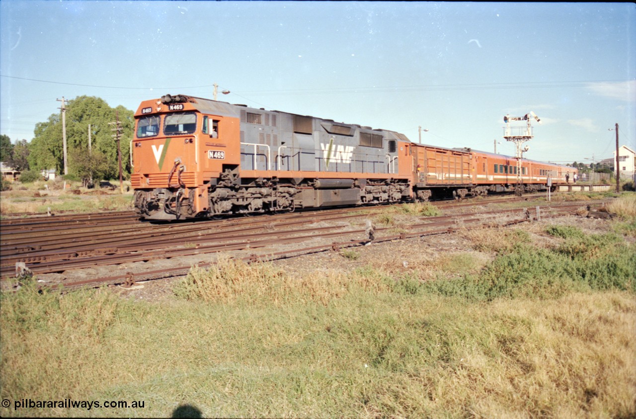 153-1-16
Bacchus Marsh, up V/Line broad gauge passenger train with N class loco N 469 'City of Morwell' Clyde Engineering EMD model JT22HC-2 serial 86-1198, D van and N set departing for Melbourne, track in foreground leads to turntable, next track to old dock road, semaphore signal post 5 pulled off for move, signal wires and point rodding.
Keywords: N-class;N469;Clyde-Engineering-Somerton-Victoria;EMD;JT22HC-2;86-1198;