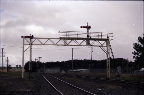 153-1-08
Ballan yard view looking towards Ballarat, signal gantry with semaphore post 6 for mainline moves, semaphore signal post 5 for the goods loop and semaphore signal post 7 up home, colour light signal post 10 in the distance.
