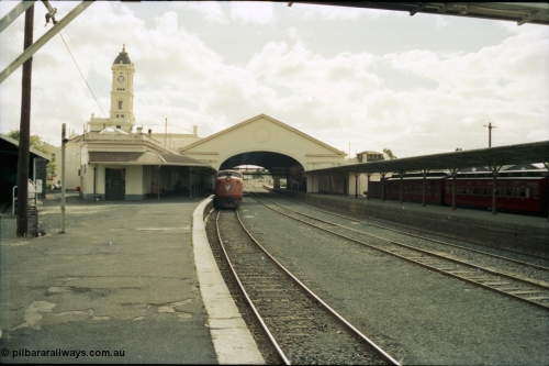 153-1-12
Ballarat station building, platform and yard overview looking from the east end of the platform and through canopy, broad gauge V/Line A class A 79 Clyde Engineering EMD model AAT22C-2R serial 84-1188 rebuilt from B 79 Clyde Engineering EMD model ML2 serial ML2-20 at platform.
Keywords: A-class;A79;Clyde-Engineering-Rosewater-SA;EMD;AAT22C-2R;84-1188;rebuild;bulldog;