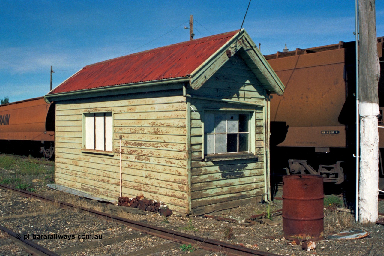 153-2-18
Ballarat station yard, weighbridge scale hut, point rodding out of hut is for selecting the points at each end of the weighbridge for either the fixed track or weigh track, V/Line bogie grain waggons.
