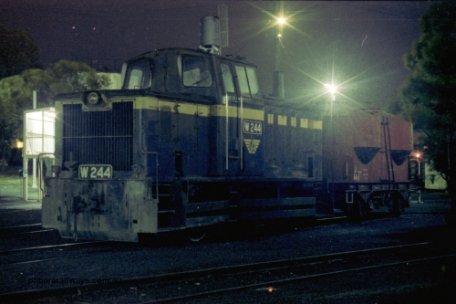 153-3-31
Geelong loco depot, stabled broad gauge Geelong shunt engine W class W 244 Tulloch Ltd model 1-MS 0-6-0 diesel hydraulic serial 9 still in Victorian Railways blue and gold livery, and J type four wheel sand waggon J 44, night shot.
Keywords: W-class;W244;Tulloch-Ltd-NSW;1-MS;9;