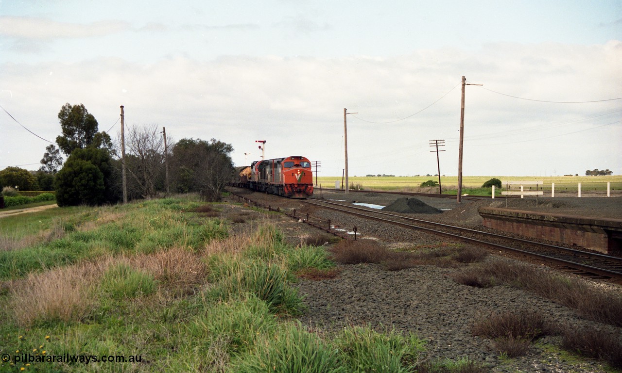 154-01
Gheringhap, V/line broad gauge goods train 9169 to Adelaide, via Cressy arrives, point rodding and station platform, taken from former No.2 platform area, triple C class Clyde Engineering EMD model GT26C on the lead.
Keywords: C-class;C510;Clyde-Engineering-Rosewater-SA;EMD;GT26C;76-833;