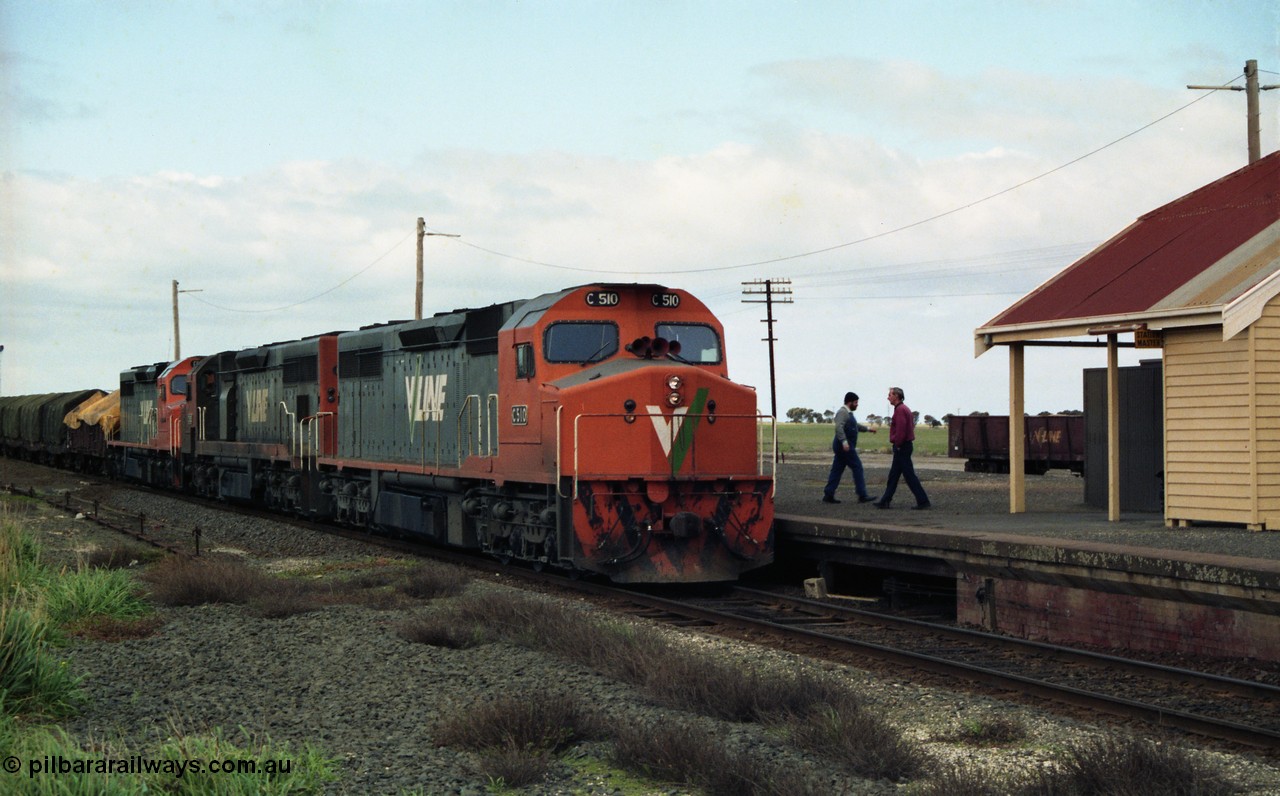 154-02
Gheringhap, V/line broad gauge goods train 9169 to Adelaide, via Cressy pauses at the station platform to swap the electric staff for a train order, crew member and Station Master on platform, C class C 510 Clyde Engineering EMD model GT26C serial 76-833 leads C 508 serial 76-831 and C class leader C 501 'George Brown' serial 76-824, VOJF type bogie gypsum waggon in background.
Keywords: C-class;C510;Clyde-Engineering-Rosewater-SA;EMD;GT26C;76-833;