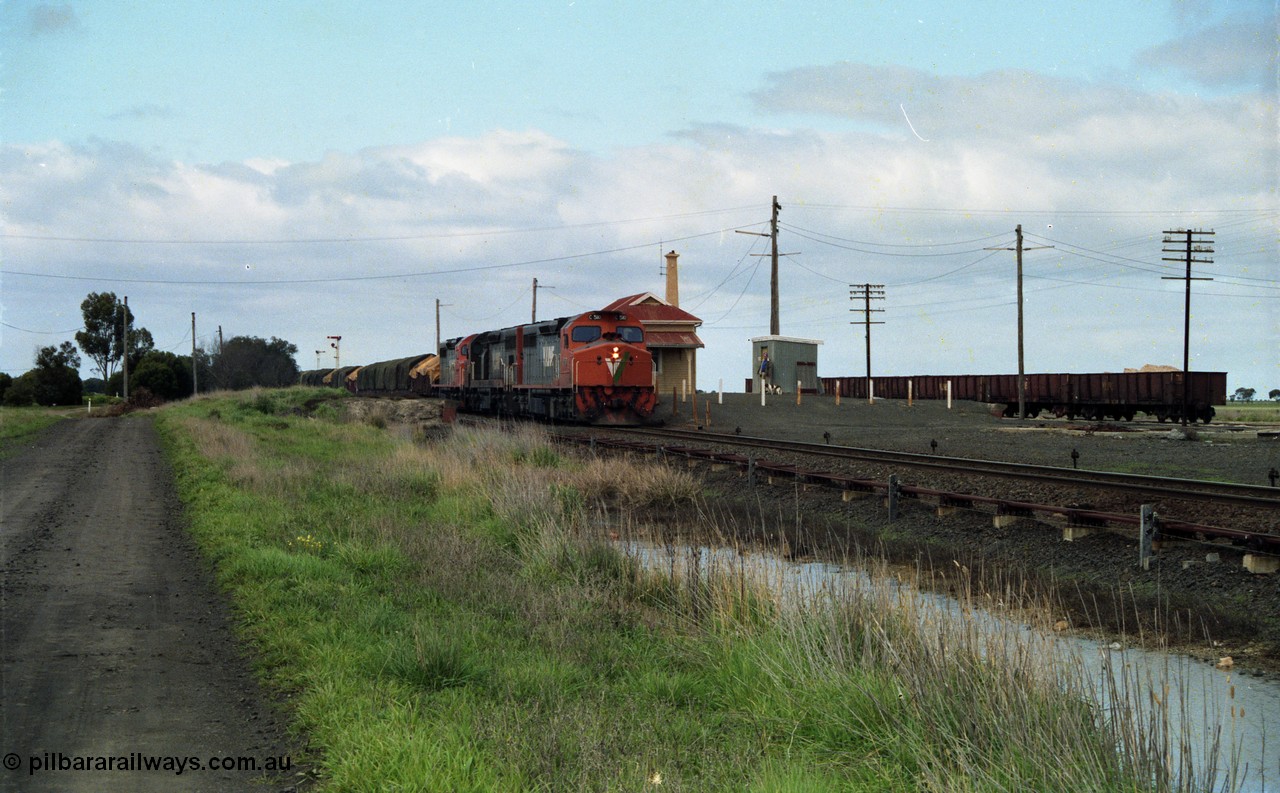 154-05
Gheringhap station yard overview, station building, shed, VOJF type bogie gypsum waggons, V/Line broad gauge goods train 9169 to Adelaide, via Cressy prepares to depart behind triple C class locomotives C 510 Clyde Engineering EMD model GT26C serial 76-833, C 508 serial 76-831 and C class leader C 501 'George Brown' serial 76-824.
Keywords: C-class;C510;Clyde-Engineering-Rosewater-SA;EMD;GT26C;76-833;