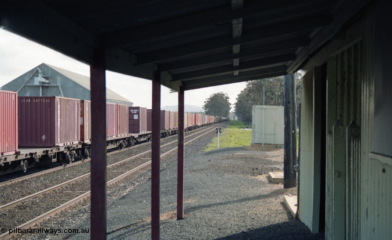 154-24
Lismore station yard overview looking west from under the veranda of the station building, ablution block, broad gauge Adelaide bound goods train 9169 running down No.2 Rd, grain bunker at left.
