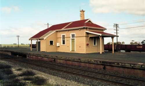 154-00
Gheringhap station building overview, platform and coping, taken from site of former No.2 platform, staff exchange box visible, gypsum waggons in yard behind station building.
