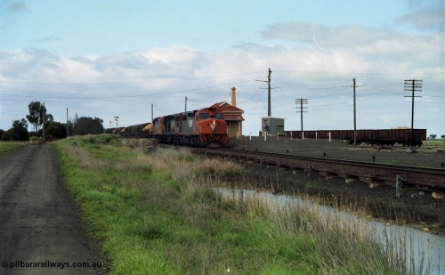 154-05
Gheringhap station yard overview, station building, shed, VOJF type bogie gypsum waggons, V/Line broad gauge goods train 9169 to Adelaide, via Cressy prepares to depart behind triple C class locomotives C 510 Clyde Engineering EMD model GT26C serial 76-833, C 508 serial 76-831 and C class leader C 501 'George Brown' serial 76-824.
Keywords: C-class;C510;Clyde-Engineering-Rosewater-SA;EMD;GT26C;76-833;
