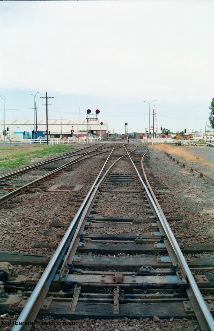 156-14
Shepparton station yard overview looking south across the High Street grade crossing from the mainline crossovers and points for the yard, searchlight signal post 12, Up home, Katamatite, now Dookie line at left, standing on Tocumwal line.
