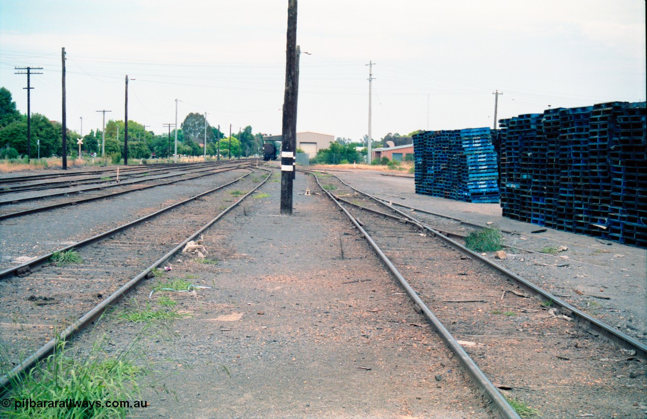 156-15
Shepparton station yard overview looking south, between No.4 and 5 Roads, fuel tanks in distance on extension of No.3 Road, track view, CHEP pallets stacked up at right.
