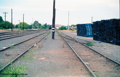 156-15
Shepparton station yard overview looking south, between No.4 and 5 Roads, fuel tanks in distance on extension of No.3 Road, track view, CHEP pallets stacked up at right.
