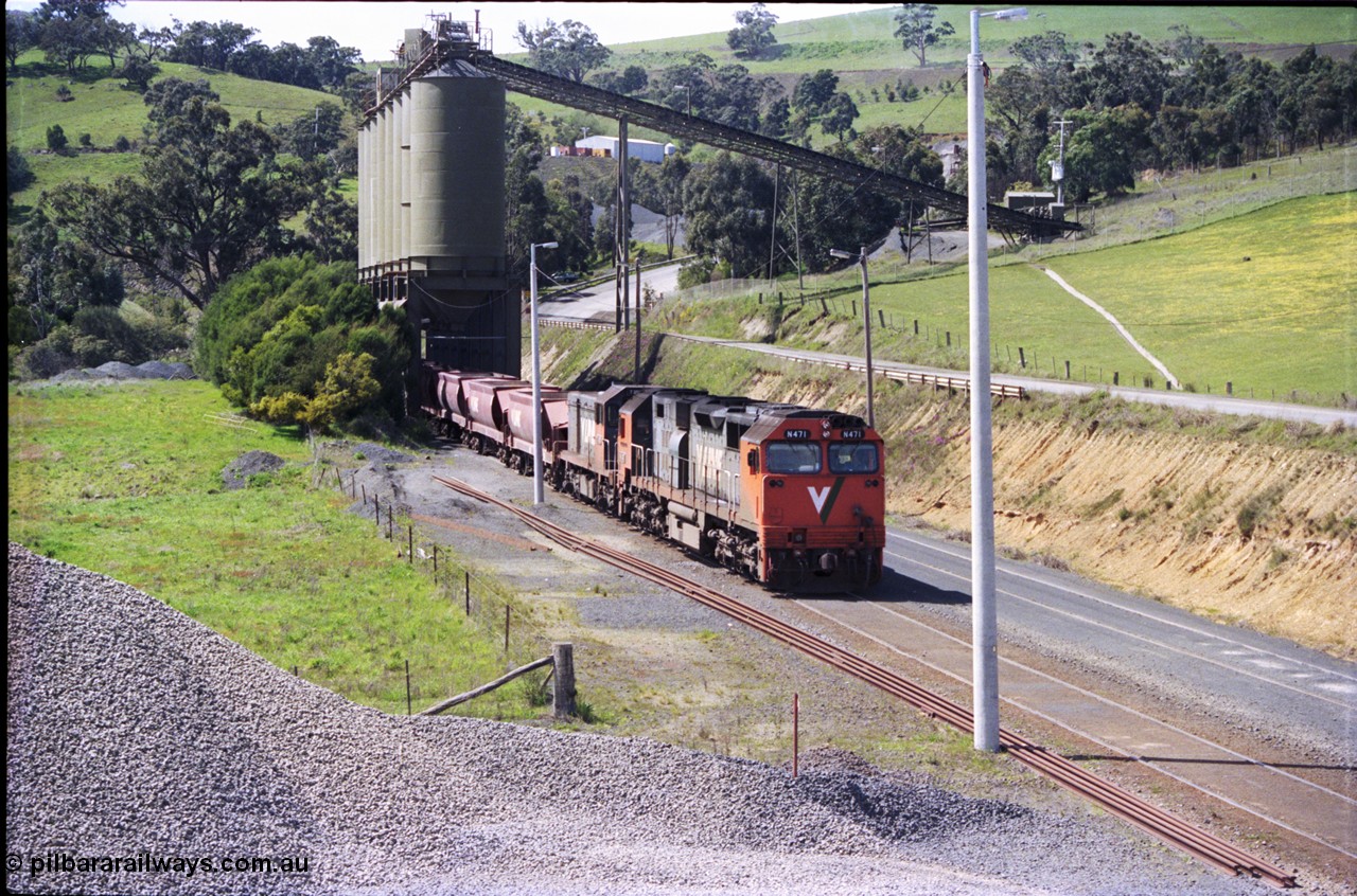 157-18
Kilmore East, Apex Quarry Siding, V/Line broad gauge locomotives N class N 471 'City of Benalla' Clyde Engineering EMD model JT22HC-2 serial 87-1200 and T class T 390 Clyde Engineering EMD model G8B serial 65-420 and type class bogie quarry products waggons pushing back under the loading bins, view taken from on top of ballast pile.
Keywords: N-class;N471;Clyde-Engineering-Somerton-Victoria;EMD;JT22HC-2;87-1200;