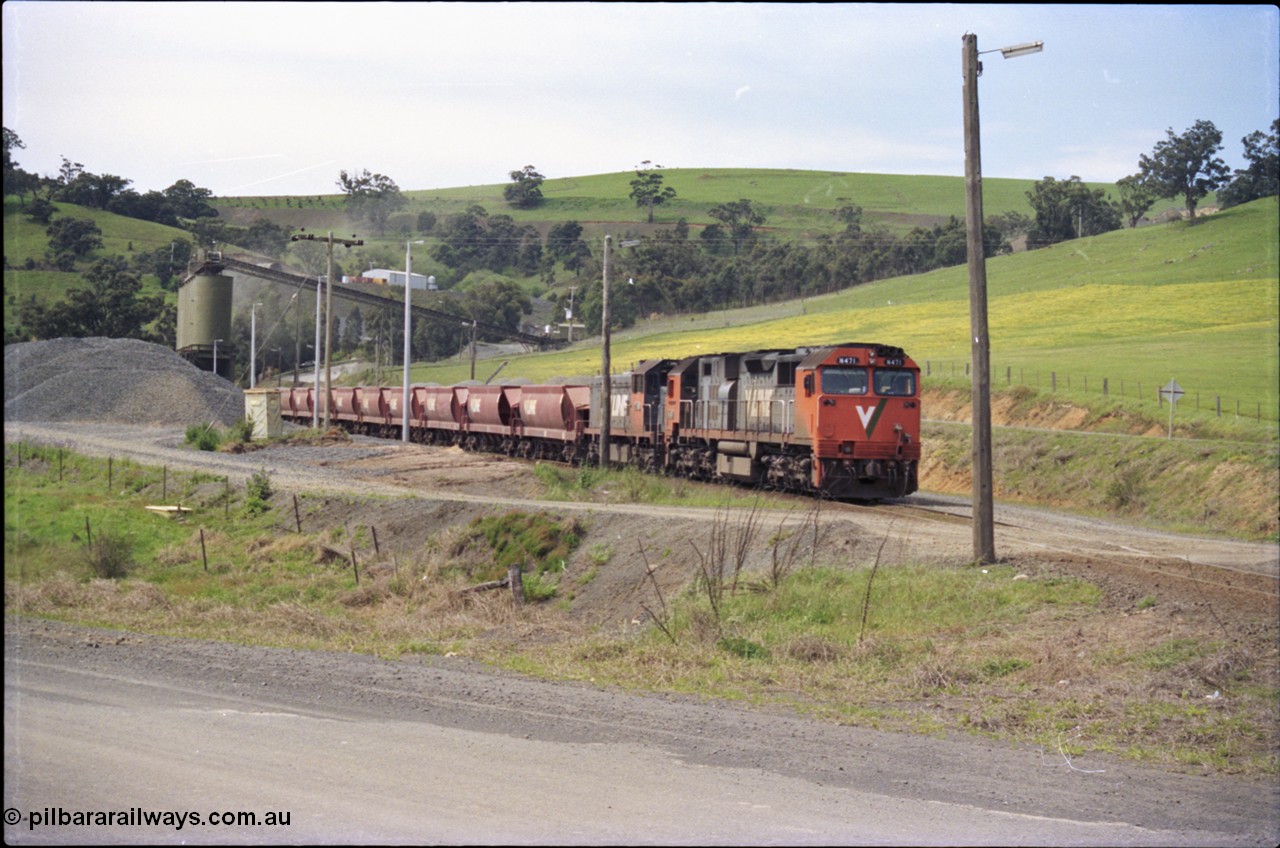 157-27
Kilmore East, Apex Quarry Siding, V/Line broad gauge locomotives N class N 471 'City of Benalla' Clyde Engineering EMD model JT22HC-2 serial 87-1200 and T class T 390 Clyde Engineering EMD model G8B serial 65-420 with train under the loading bins during loading operations, view across Broadford - Kilmore Road.
Keywords: N-class;N471;Clyde-Engineering-Somerton-Victoria;EMD;JT22HC-2;87-1200;