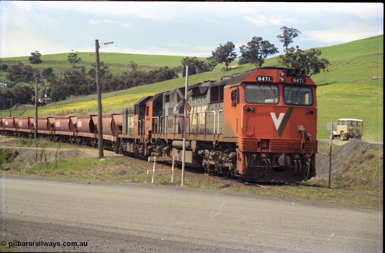 157-32
Kilmore East, Apex Quarry Siding, V/Line broad gauge locomotives N class N 471 'City of Benalla' Clyde Engineering EMD model JT22HC-2 serial 87-1200 and T class T 390 Clyde Engineering EMD model G8B serial 65-420 with train under the loading bins during loading operations, view across Broadford - Kilmore Road.
Keywords: N-class;N471;Clyde-Engineering-Somerton-Victoria;EMD;JT22HC-2;87-1200;