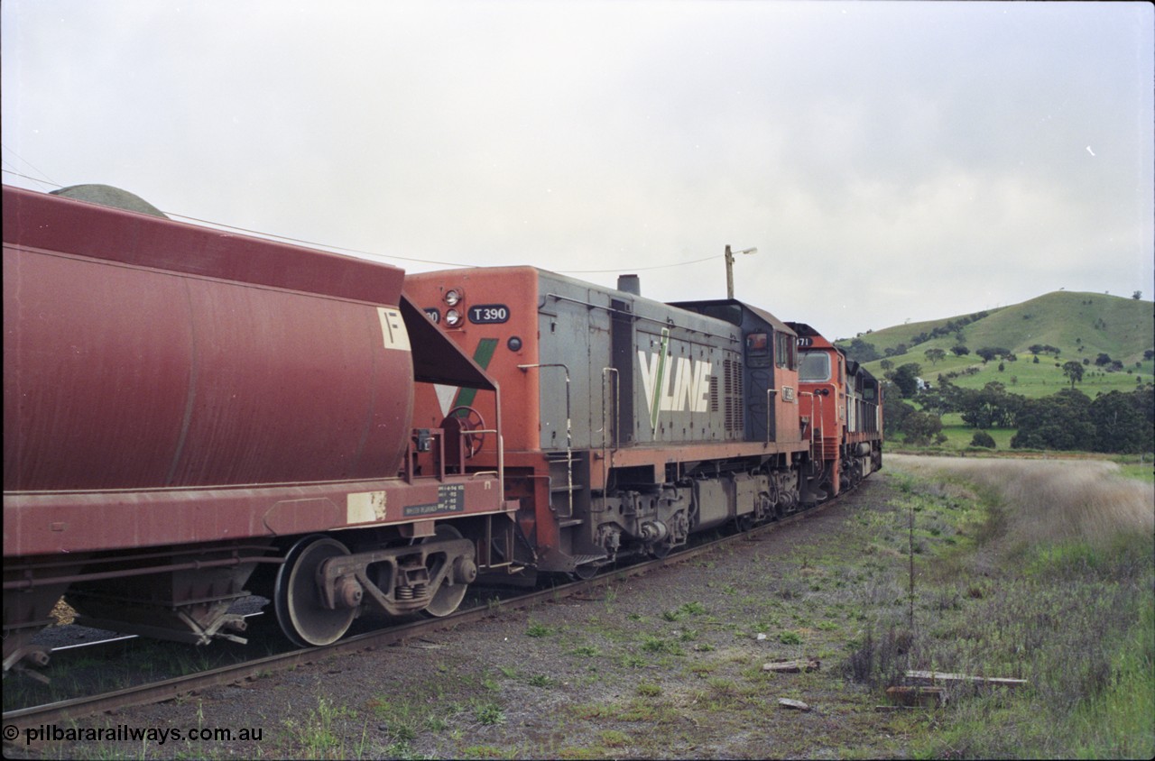 157-34
Kilmore East, Apex Quarry Siding, V/Line broad gauge locomotives N class N 471 'City of Benalla' Clyde Engineering EMD model JT22HC-2 serial 87-1200 and T class T 390 Clyde Engineering EMD model G8B serial 65-420 and VHQF type bogie quarry products waggon VHQF 414, trailing view.
Keywords: T-class;T390;Clyde-Engineering-Granville-NSW;EMD;G8B;65-420;