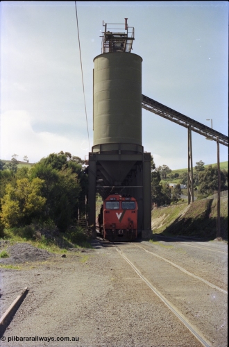 157-19
Kilmore East, Apex Quarry Siding, V/Line broad gauge locomotives N class N 471 'City of Benalla' Clyde Engineering EMD model JT22HC-2 serial 87-1200 with train under the loading bins as loading of the train commences, front vertical view.
Keywords: N-class;N471;Clyde-Engineering-Somerton-Victoria;EMD;JT22HC-2;87-1200;
