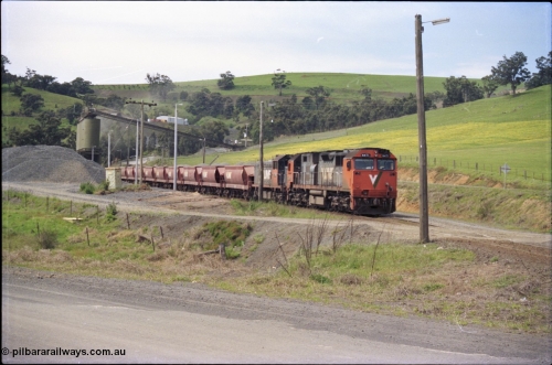 157-27
Kilmore East, Apex Quarry Siding, V/Line broad gauge locomotives N class N 471 'City of Benalla' Clyde Engineering EMD model JT22HC-2 serial 87-1200 and T class T 390 Clyde Engineering EMD model G8B serial 65-420 with train under the loading bins during loading operations, view across Broadford - Kilmore Road.
Keywords: N-class;N471;Clyde-Engineering-Somerton-Victoria;EMD;JT22HC-2;87-1200;