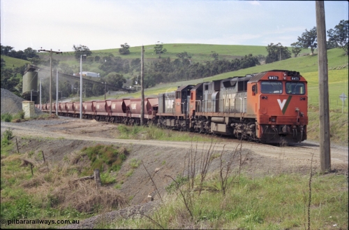 157-28
Kilmore East, Apex Quarry Siding, V/Line broad gauge locomotives N class N 471 'City of Benalla' Clyde Engineering EMD model JT22HC-2 serial 87-1200 and T class T 390 Clyde Engineering EMD model G8B serial 65-420 with train under the loading bins during loading operations, view from Broadford - Kilmore Road.
Keywords: N-class;N471;Clyde-Engineering-Somerton-Victoria;EMD;JT22HC-2;87-1200;