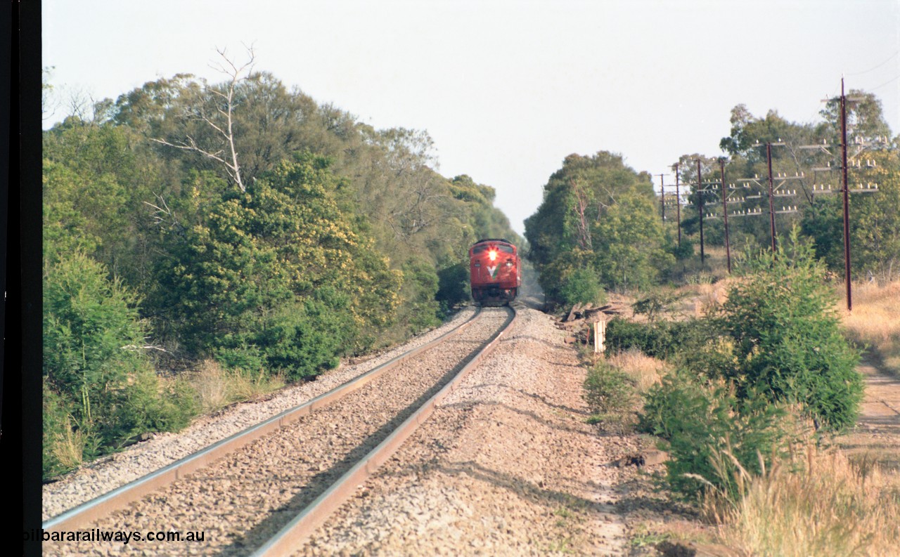 159-02
Bank Box Loop, V/Line broad gauge A class locomotive leads a down passenger train near the grade crossing west of the crossing loop.
