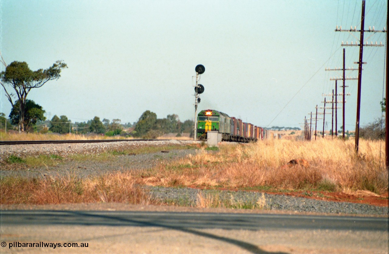 159-08
Rockbank, double Australian National broad gauge BL class locomotives lead a down Adelaide bound goods train at the down home signal post for the crossing loop.

