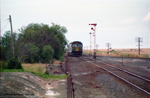 159-10
Gheringhap, track view looking east towards Geelong from the former No.2 platform, signal rodding running along edge of platform, semaphore signal post 3, Australian National broad gauge BL class BL 27 Clyde Engineering EMD model JT26C-2SS serial 83-1011 leads down goods train 9169 as it arrives on their way to Adelaide.
